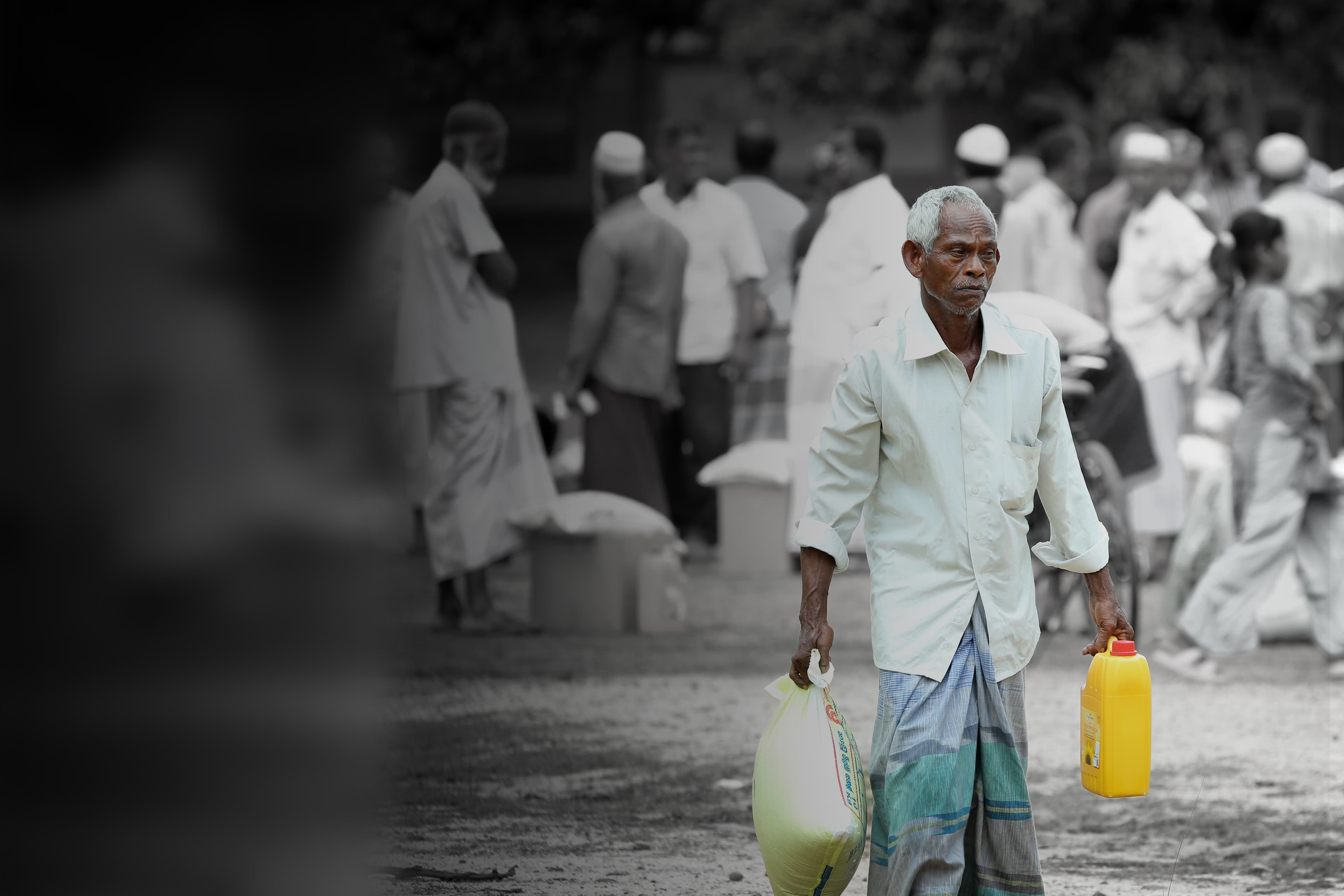 An elderly man receiving food aid at an ALKUF distribution